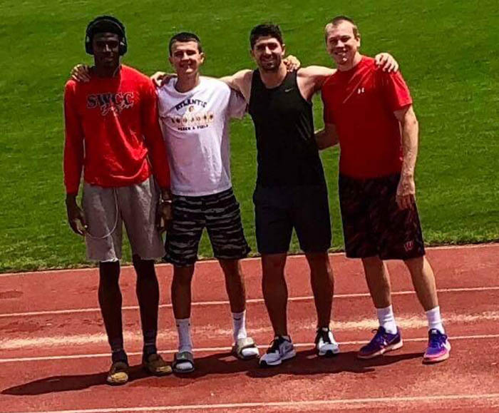 Spartan student-athletes with coach on the track