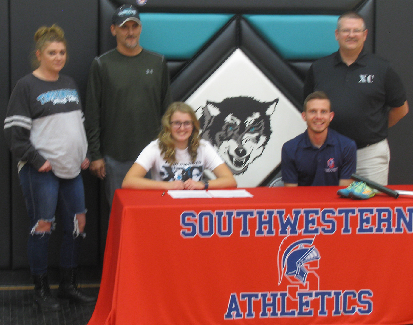 Maslyn Hummel, her family, and Southwestern Spartan Head Cross Country Coach Trey Bruton.