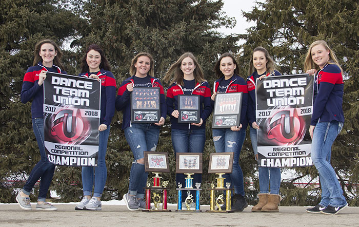 Dazzlers team members with trophies and banners