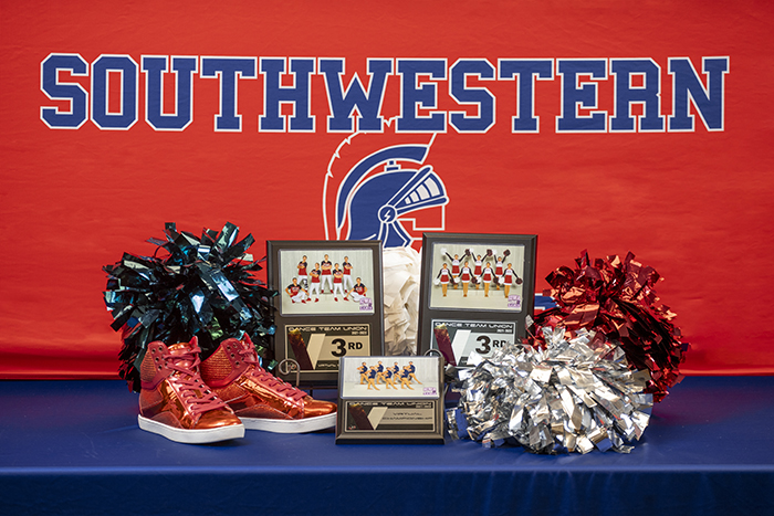 Trophies with dance shoes and pom poms.