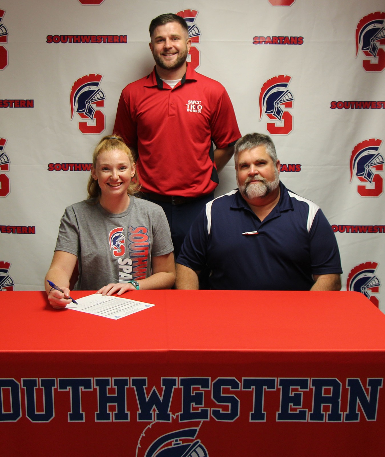 Sitting (L to R) – Ella Rutherford and Scott Rutherford, Ella’s father. Standing – Nick Weinmeister, Southwestern head softball coach.