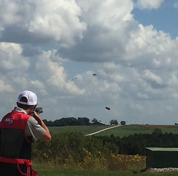 Spartan male sports shooter shoots at targets flying through the air.