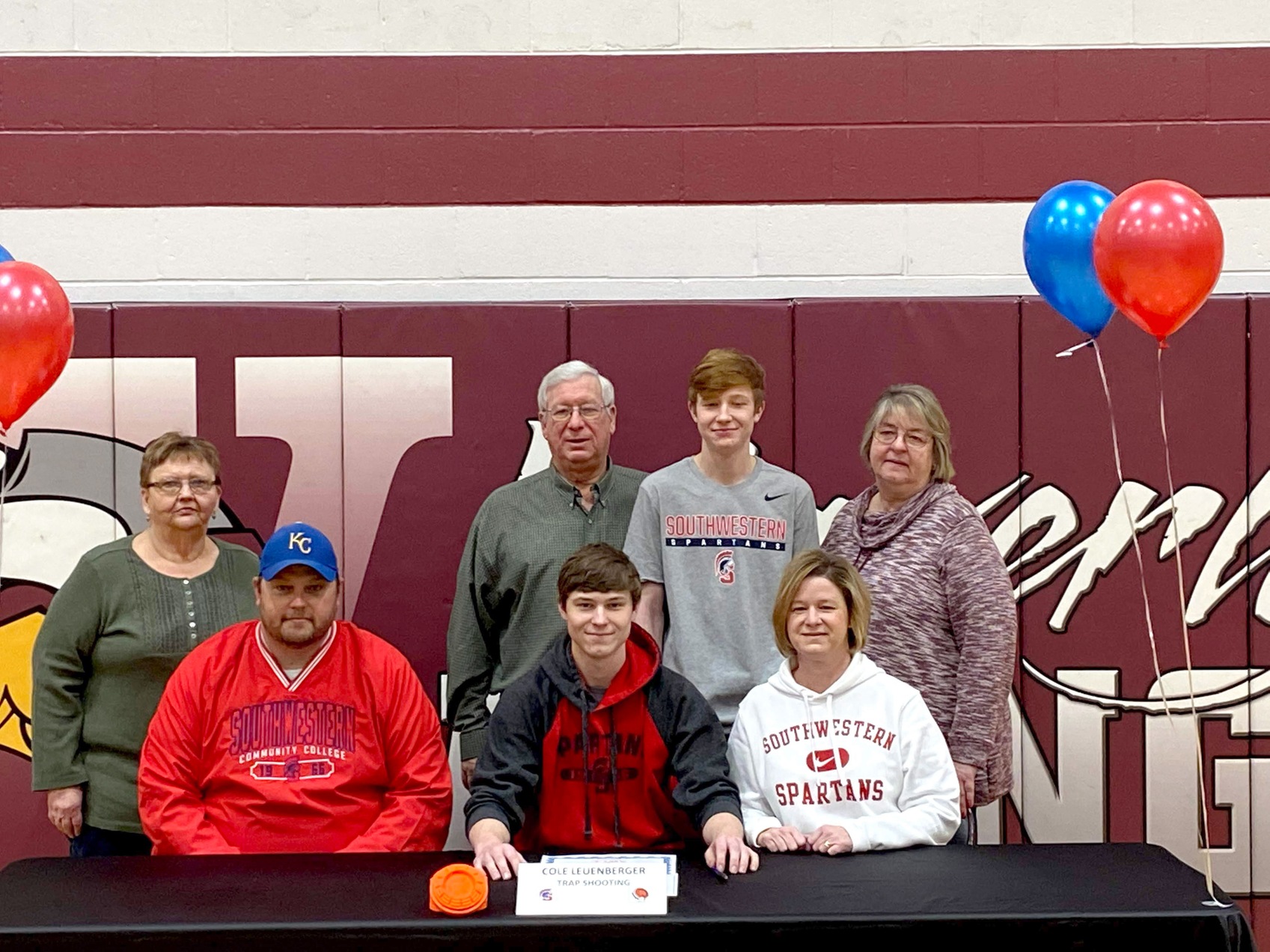 Cole Leuenberger signs with Southwestern's sports shooting team.